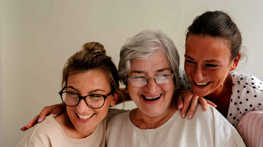 Mujer mayor sonriente y sus hijas